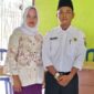 Darmawan, S.E didampingi Istri Nuraida, A.md, Keb, saat penyerahan berkas pendaftaran di Kantor Desa Pagar Puding Lamo